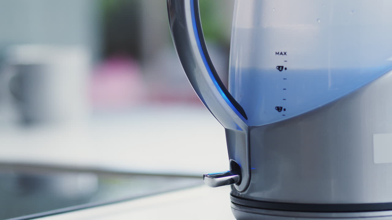 집에서 전기 ketel를 기 위해 전원 스위치를 누르는 여성의 근접