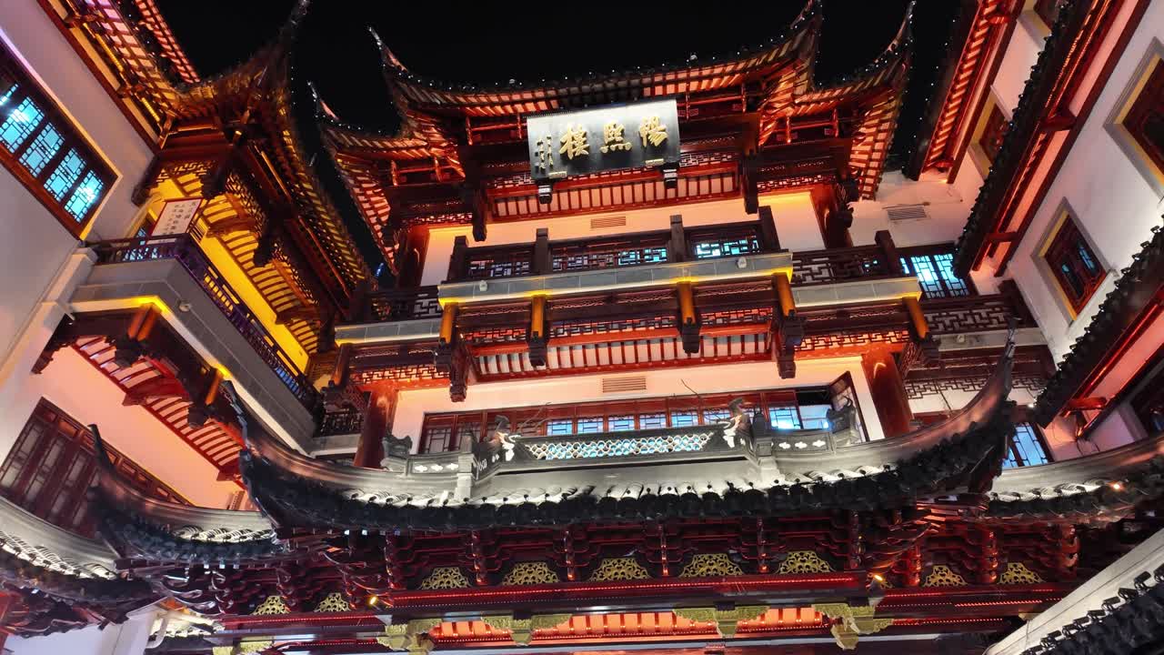 Et filmatisk nattbilde gjennom Yuyuans tradisjonelle arkitektur, hvor gylne lys belyser buede tak og historiske gater i Shanghais gamleby.