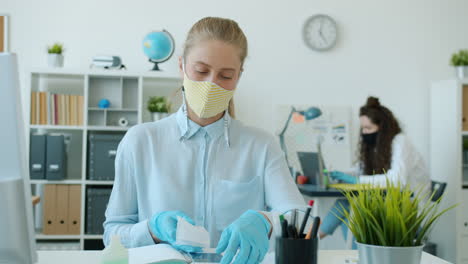 woman working from home in office, wearing protective mask and gloves