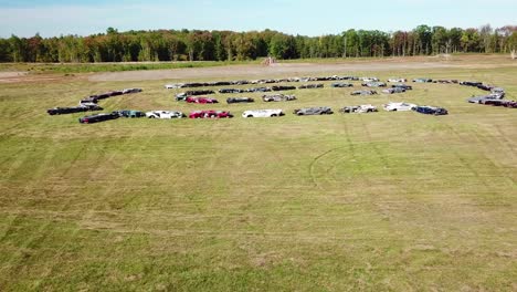 an aerial over a circle of crushed cars in a large field near portland maine