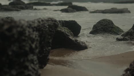 Cinematic-slow-motion-shot-on-the-sea-gracefully-flows-into-a-stunning-collection-of-tropical-volcanic-rocks-in-India,-capturing-the-mesmerizing-beauty-of-the-natural-landscape