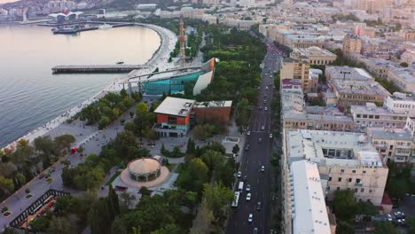 aéreo <unk> parque natural a lo largo de la costa y las calles del casco antiguo de baku después del atardecer, azerbaiyán