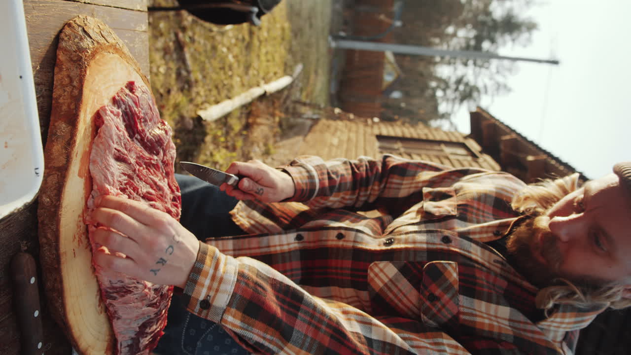 hombre cortando carne para cocinar en la parrilla de barbacoa