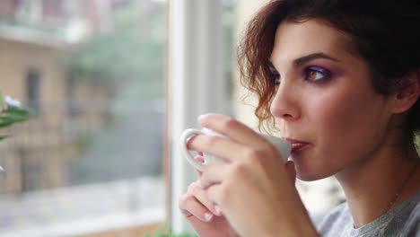 Hermosa-Joven-Soñando-Con-Una-Taza-De-Café-Caliente-Sobre-La-Ventana.-Vista-De-Cerca.-Tiro-En-Cámara-Lenta