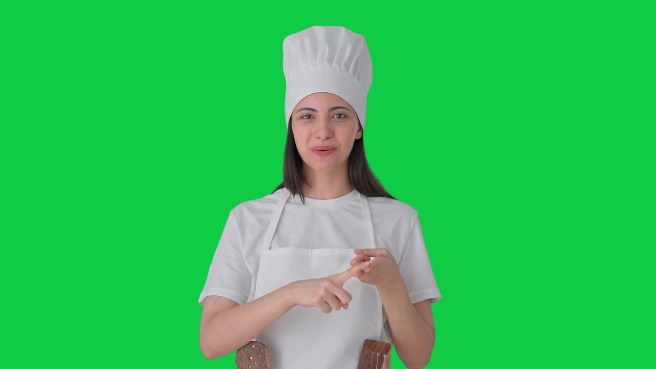 Felice chef professionista indiana che parla alla telecamera su schermo verde