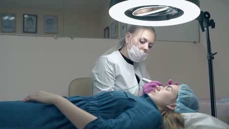 mujer con cabello largo y blanco aplica maquillaje permanente para las cejas