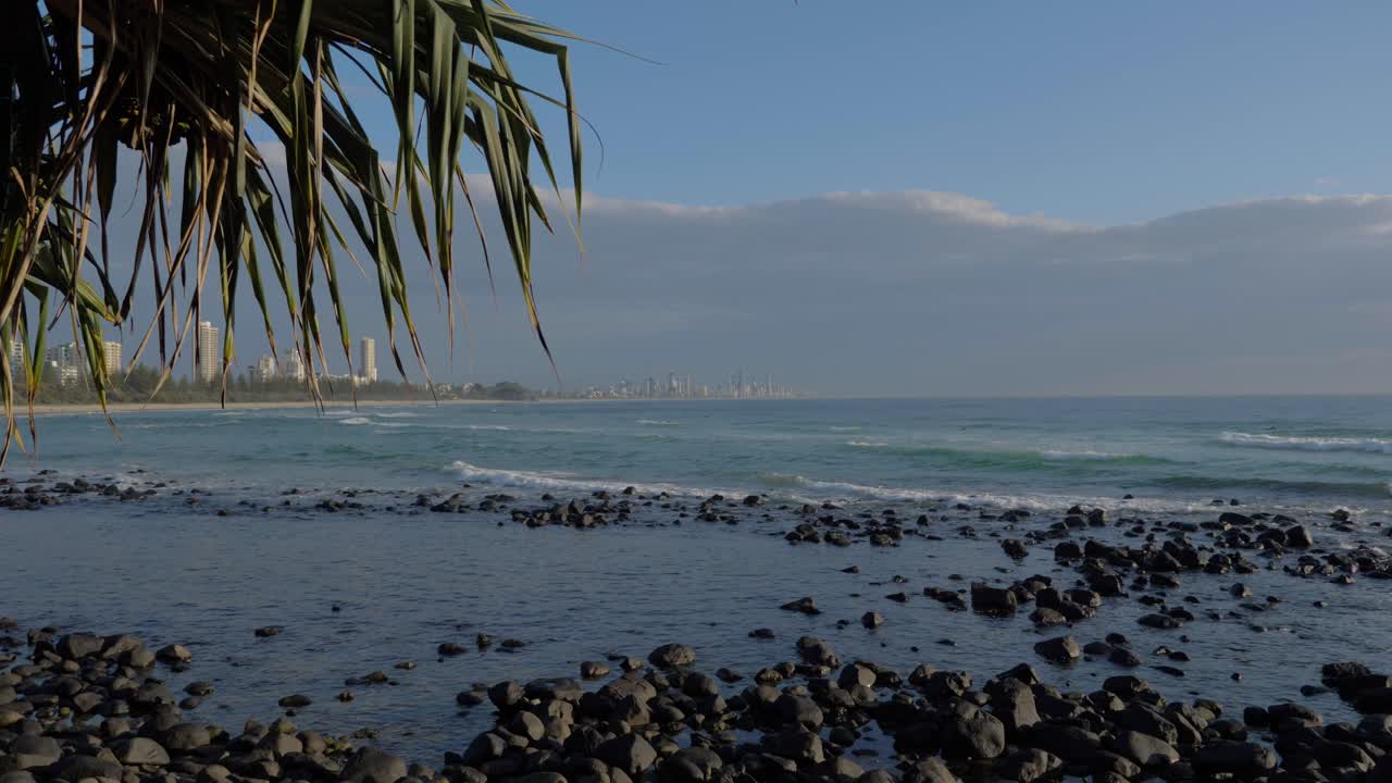 rocas en alta mar con olas de mar en calma bajo nubes - playa de burleigh heads - paraíso de los surfistas en la costa dorada, queensland, australia