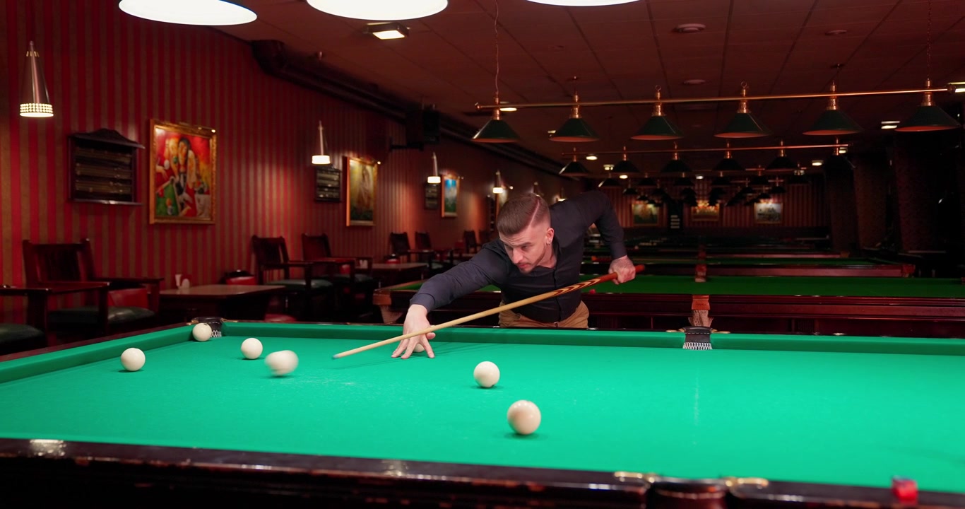 Focused Man Playing Billiards in a Classic Pool Hall