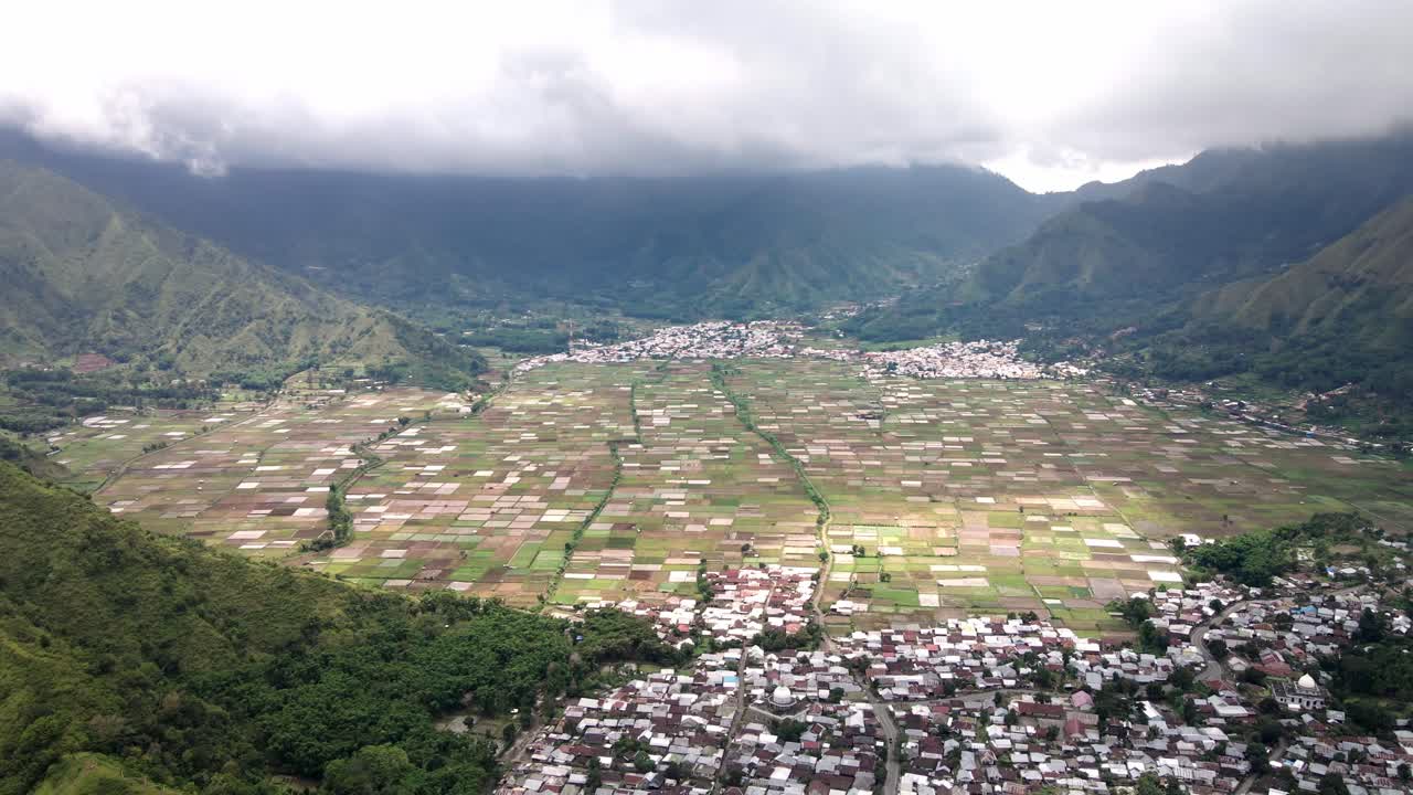 tiro épico de drone do vale e da terra agrícola da vila de sembalun com a cordilheira do vulcão ao fundo, perto do parque nacional do vulcão rijani, lombok, indonésia
