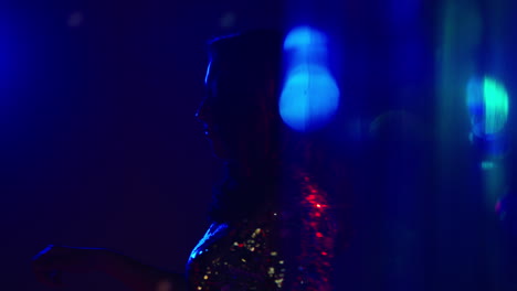 close up of woman having fun dancing in disco nightclub or bar shot with tinsel in foreground 2