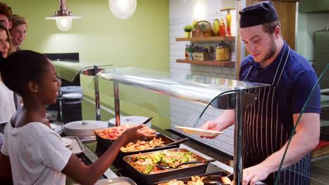 teenage students being served meal in school canteen