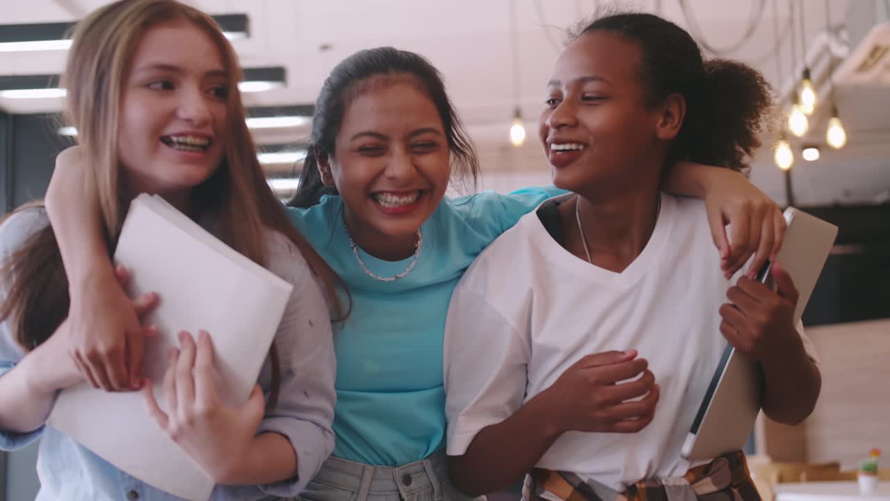 Multiethnic students having fun chatting in school talking and laughing together.