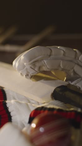 vida muerta de cricket con close up de guantes de pelota de murciélago troncos saltador y bailes que se encuentran en la superficie de madera en el vestuario 3