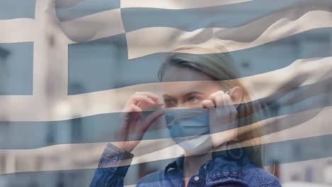 Animation-of-flag-of-greece-waving-over-caucasian-woman-wearing-face-mask-in-city-street