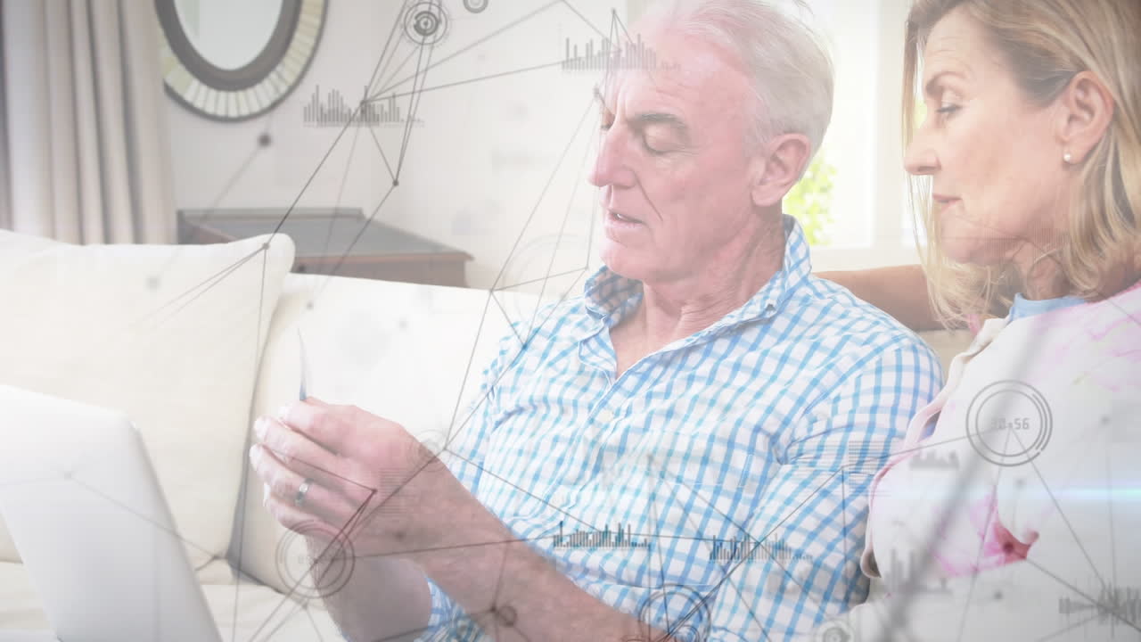 pareja de ancianos caucásicos en distanciamiento social comprando en línea en casa