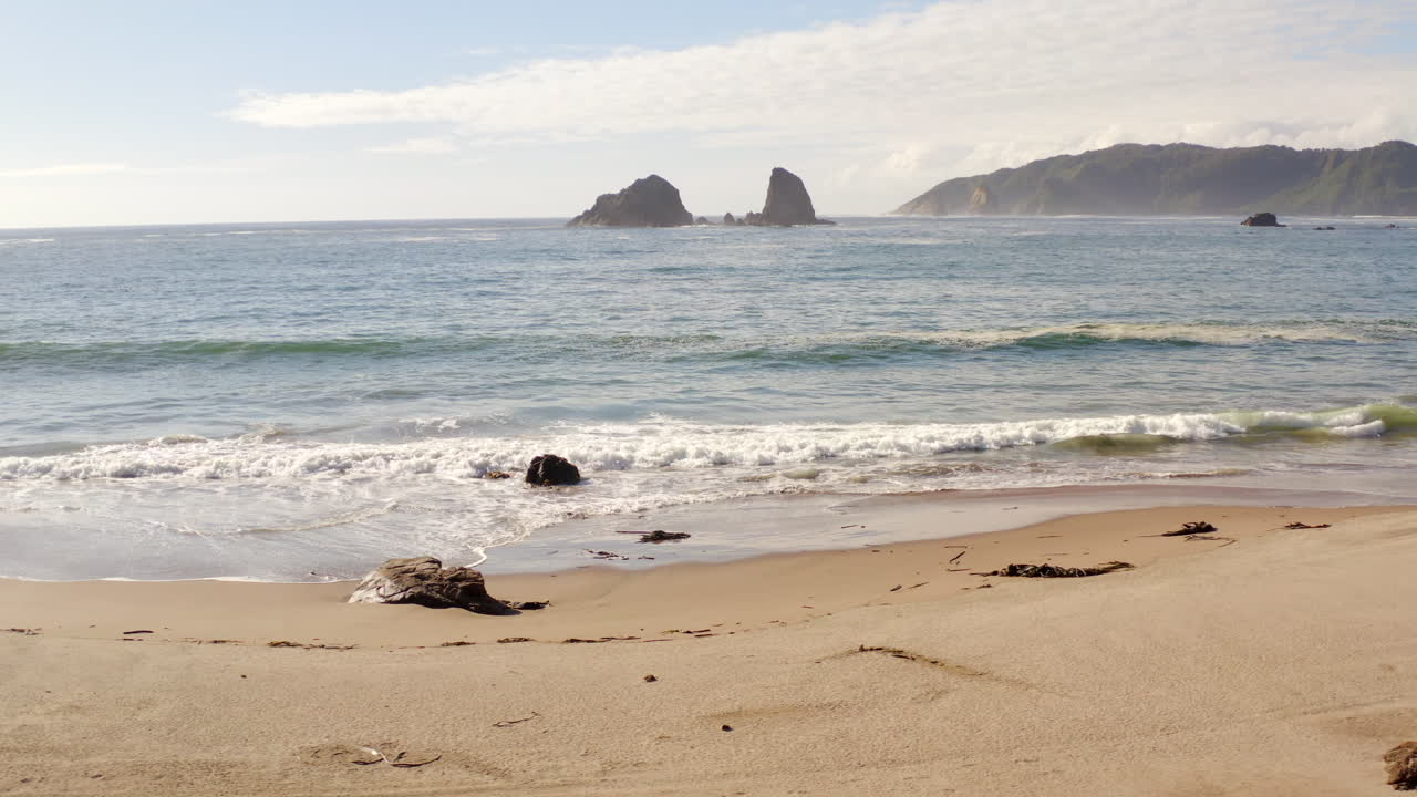 Esta é a praia de Epu com dunas, ilha vulcânica e areia branca.
