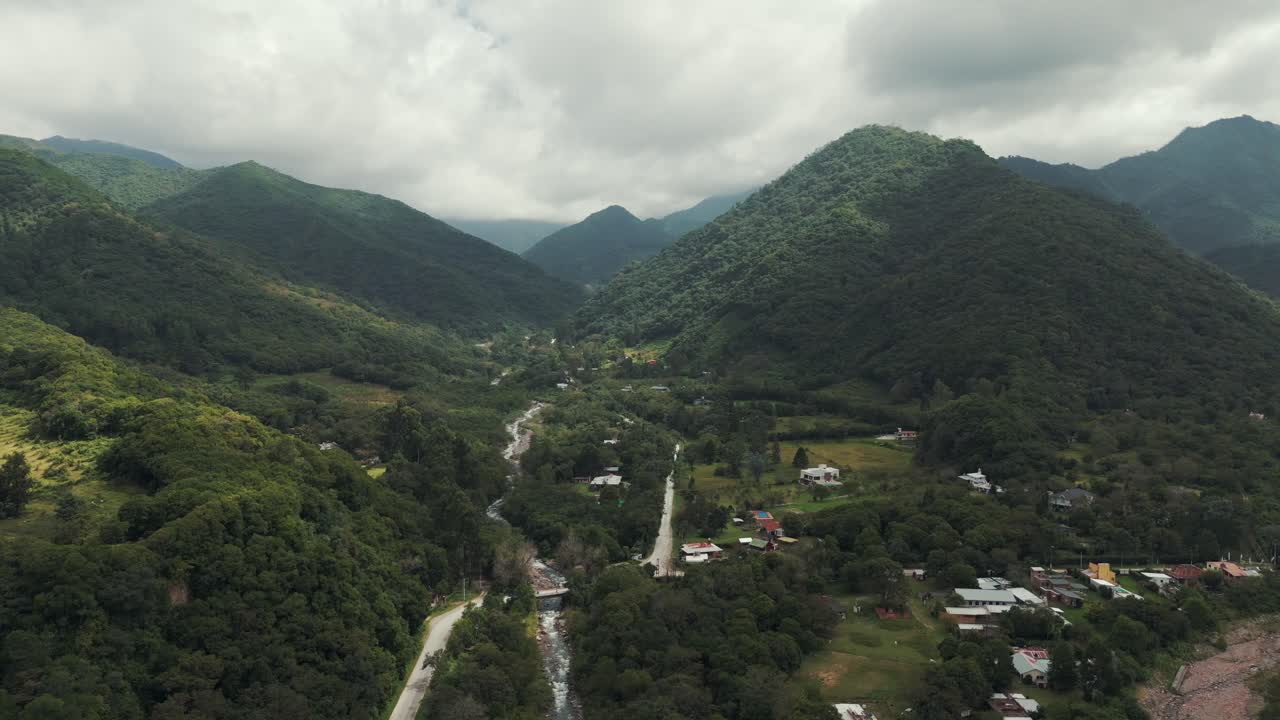 Aerial view of a valley with a river, road, and houses