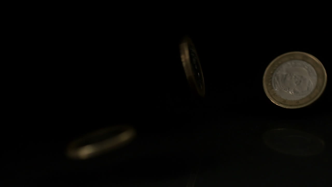 las monedas de euro que caen sobre una superficie negra