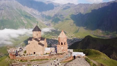 aerial of the gergeti monastery and church overlooking the caucasus mountains in the republic of georgia