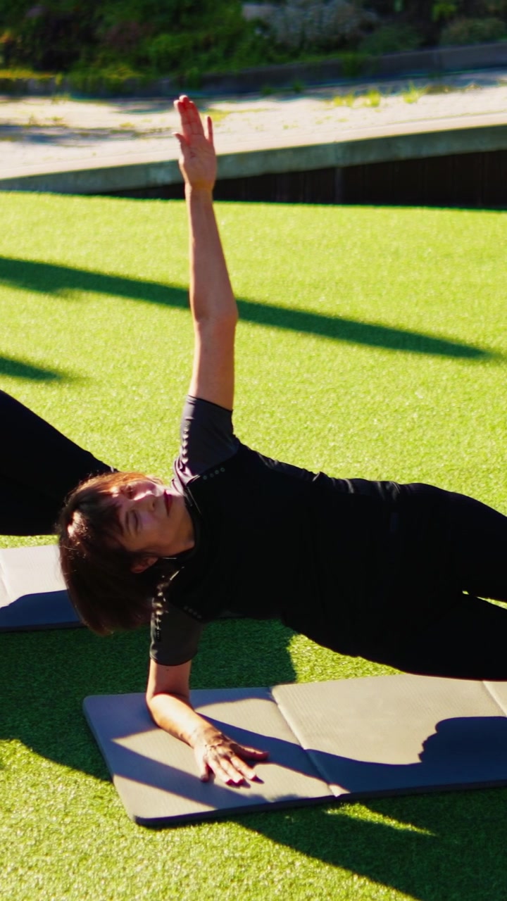 Woman Performing Side Plank Exercise on Yoga Mat Outdoors