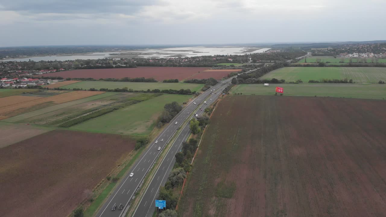 vista aérea de drones que muestra la concurrida carretera húngara, hermoso lago en el fondo
