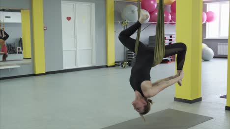 woman practicing aerial yoga inversion pose