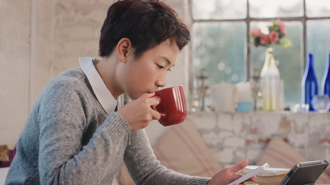 아침에 커피를 마시며 집에서 스마트 폰을 사용하는 젊은 학생