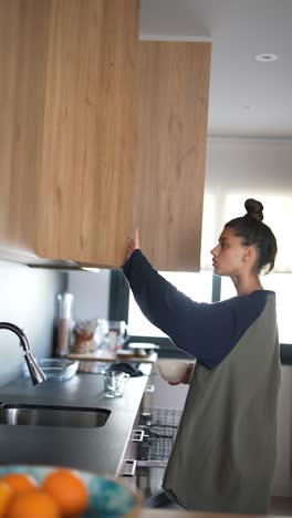 woman reaching for high kitchen cabinets