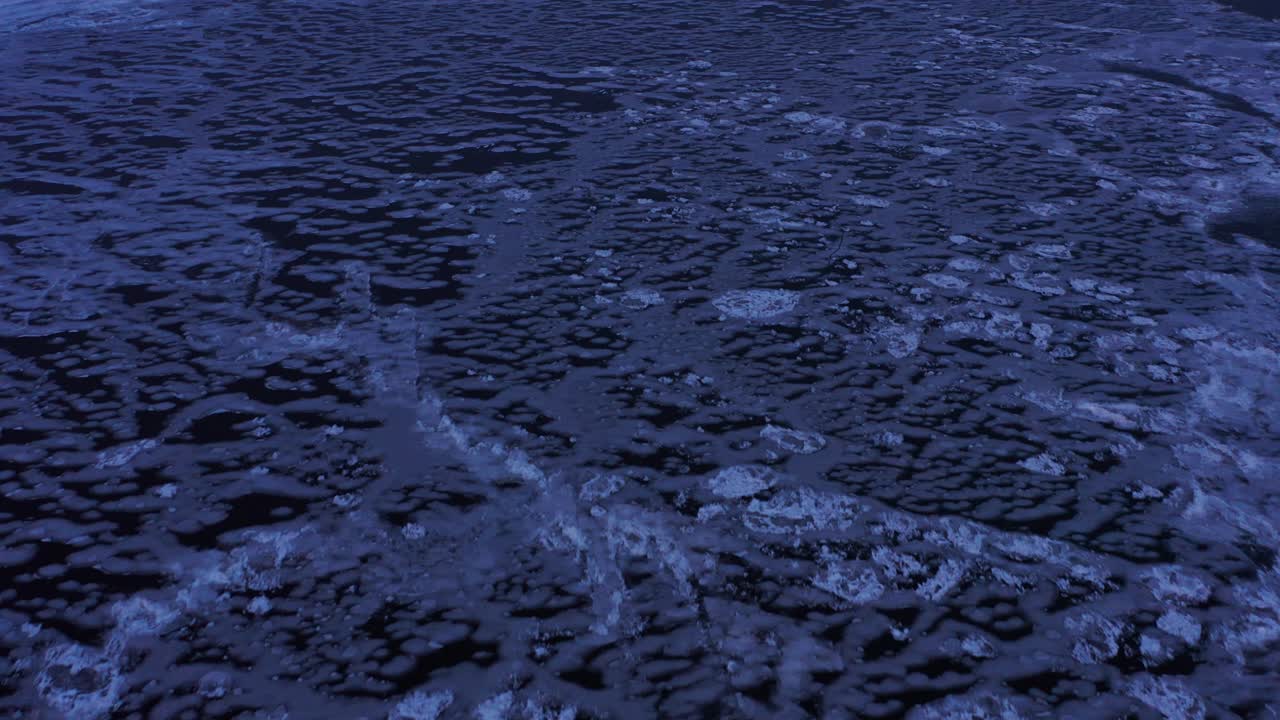 aerial view of frozen blue ice on lake superior at twilight