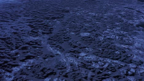 aerial view of frozen blue ice on lake superior at twilight