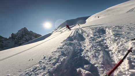 pov-aufnahme eines skifahrers, der verschneite berge hinunterfährt und an einem sonnigen tag abstürzt