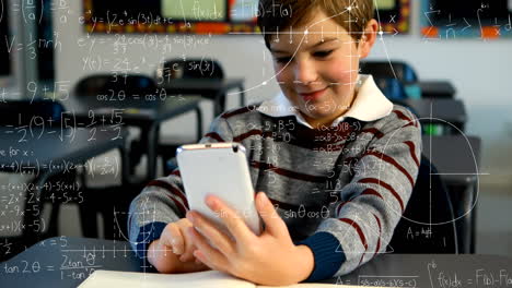 mathematical equations floating against boy using smartphone in class at school