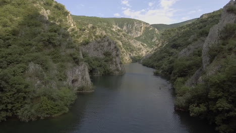 aerial shot of a kayaker paddling through a mountain valley