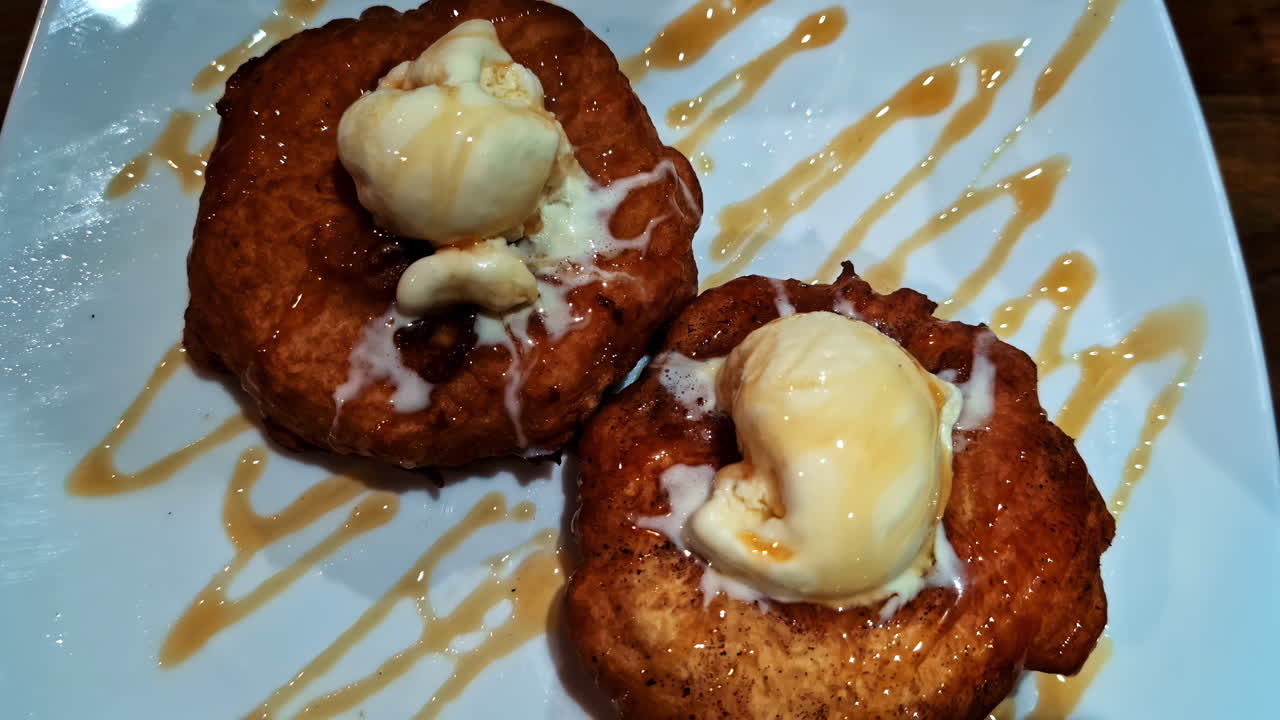 Golden Fried Dough Pastries Topped With Melting Ice Cream And Drizzled With Caramel Sauce. Zoom In