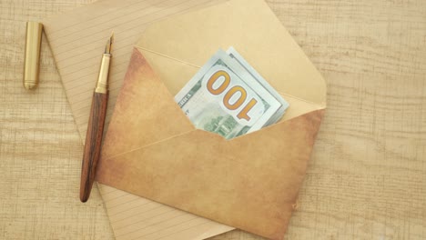 money in an envelope with a fountain pen and stationary