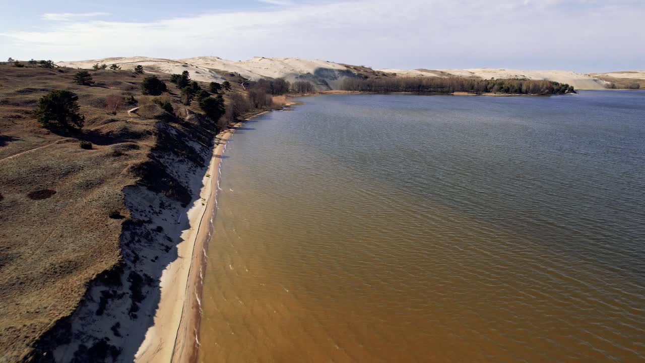 vuelo aéreo sobre la costa de la playa de arena en el parque nacional de naglis, istmo de curlandia, lituania