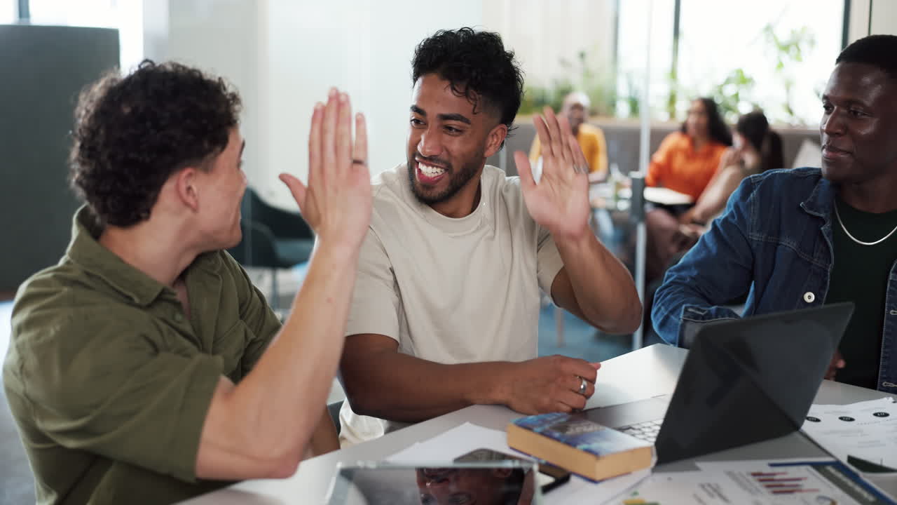 Diverse Group of Young Men High-Fiving During a Collaborative Study Session