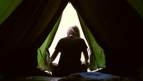 woman sat in tent doorway