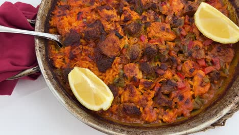 Plato-Tradicional-De-Paella-Española-Con-Pollo,-Verduras-Y-Rodajas-De-Limón-En-Un-Restaurante,-Sabroso-Marisco-En-Marbella-España,-Tiro-De-4k