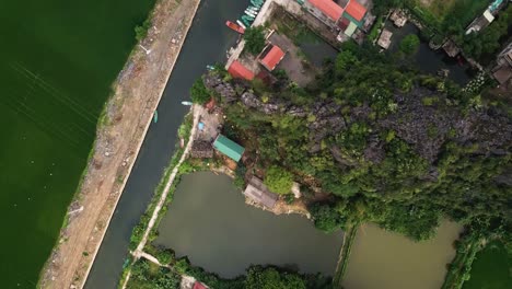 aerial shot of houses or businesses along a canal with a reveal of small boats