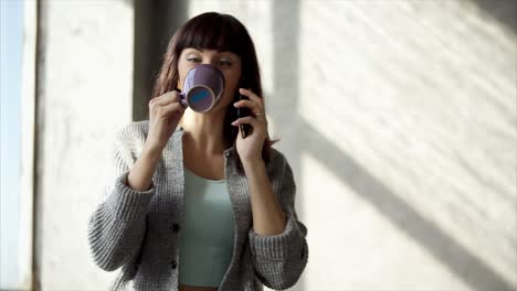woman drinking coffee and talking on phone