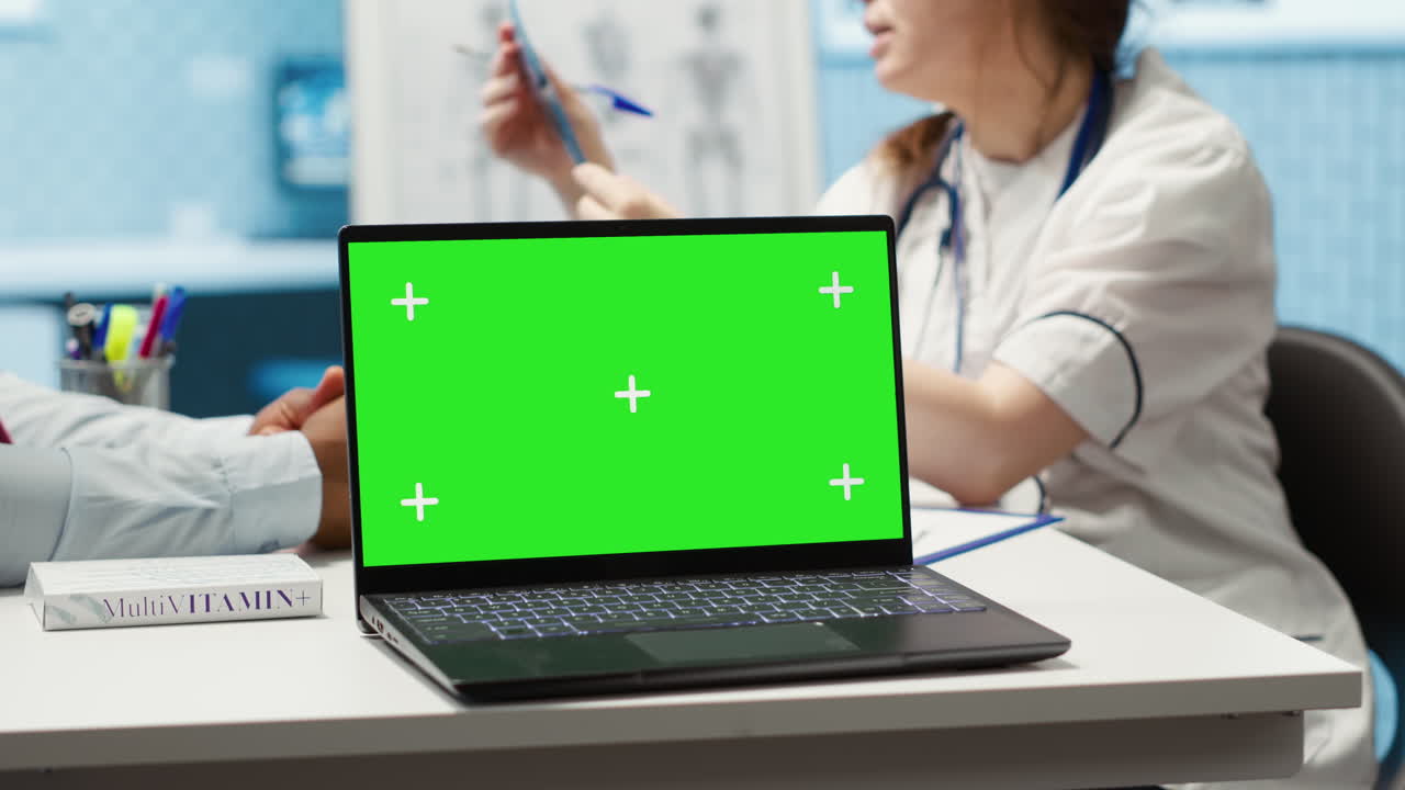 el médico de cabecera y el paciente miran la pantalla verde del dispositivo