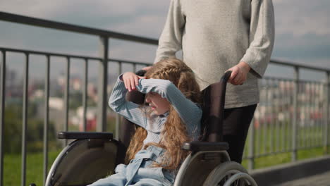 girl with leg injury looks at city covering eyes from sun