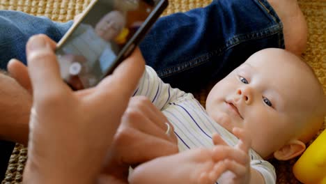 father taking picture of his baby boy at home 4k