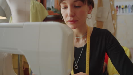 costurera usando la máquina de coser en el trabajo en el estudio de confección