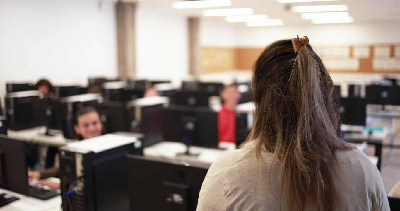 Insegnante in piedi davanti agli studenti in aula informatica