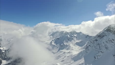 Rocky-mountains-covered-in-pure-white-snow,-aerial-drone-view