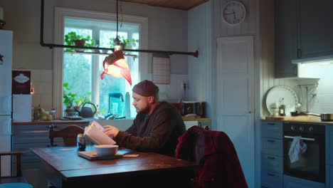 man reading a book in a cozy kitchen