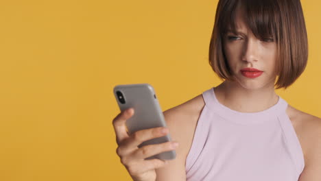 unhappy woman with smartphone in studio