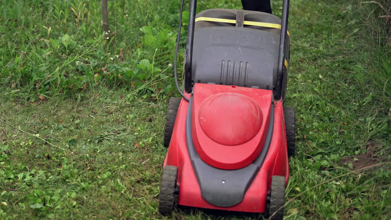 Lawn Mower in action. Summer seasonal works in backyard.